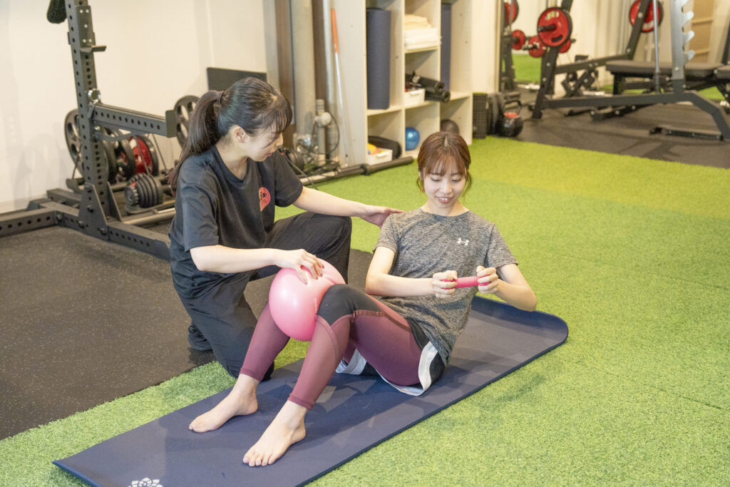 女性パーソナルトレーナーのトレーニングを受ける女性の写真