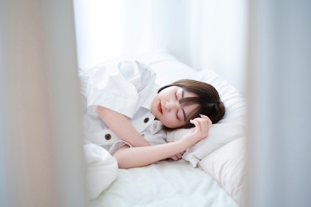 横になって眠っている女性の写真