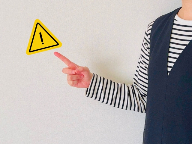 注意サインを指す女性の写真