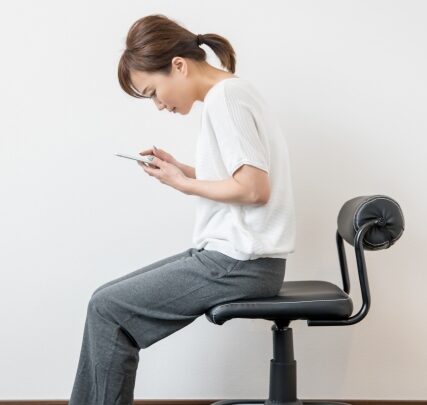 スマホ猫背の女性