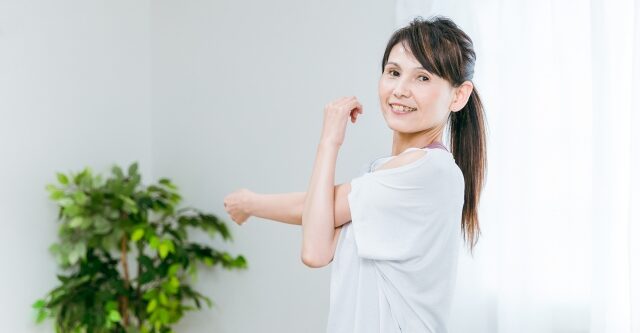ストレッチする中高年女性（ヨガウェア）